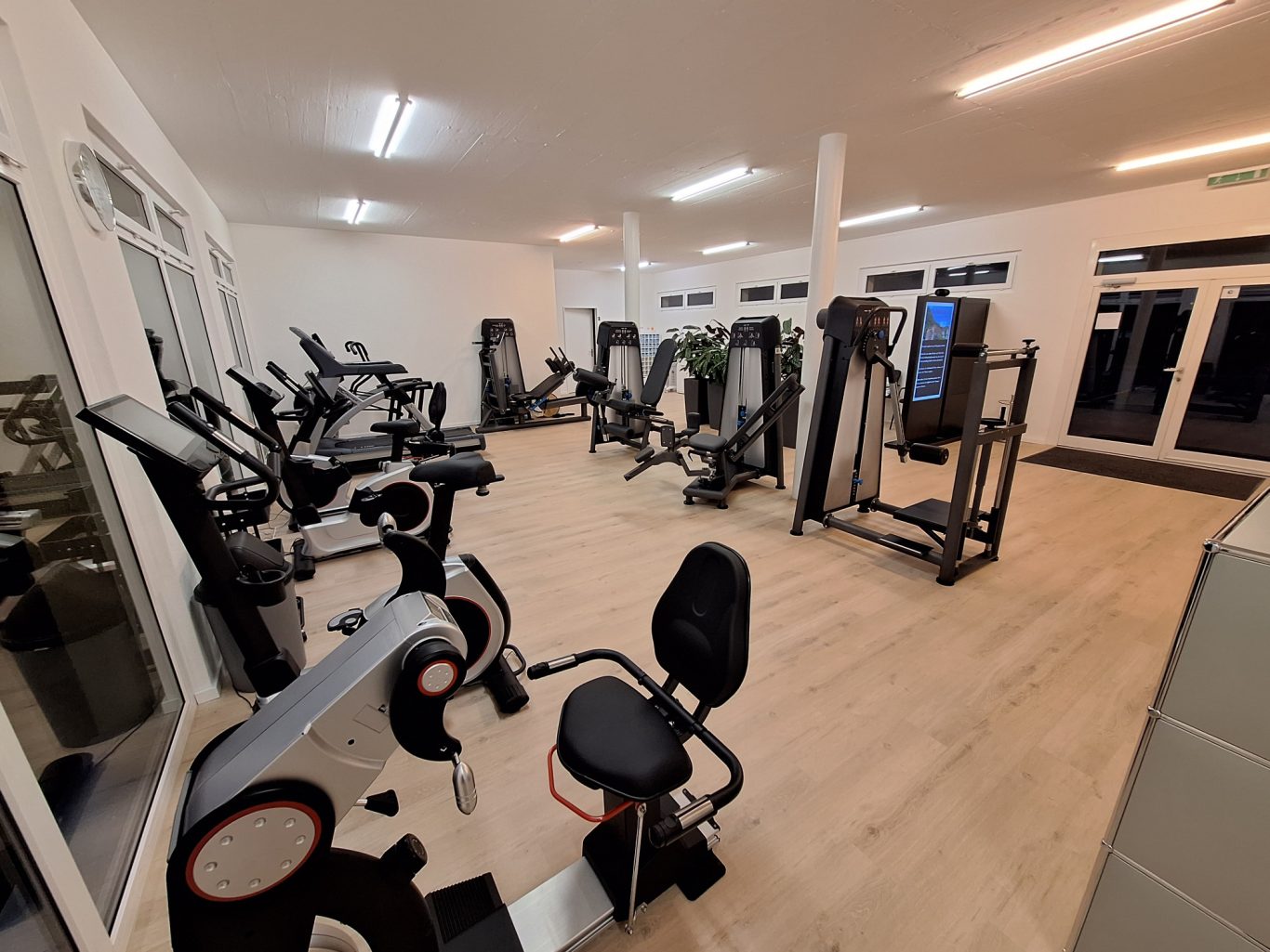 Moderne Fitnessgeräte in einem hellen, gut ausgestatteten Fitnessstudio.